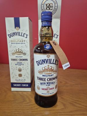 La bouteille de « Three Crowns » de Dunville se trouve à côté d'une caisse de whisky