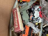 a cardboard box full of toy cars and trucks