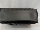 a black leather purse with a long strap on it
