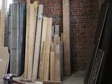 several pieces of wood are stacked up in a room with a brick wall