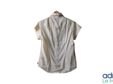 a white shirt hanging on a hanger on a white wall