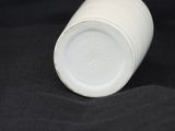 a white cup sitting on a black surface