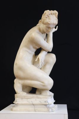 marble statue of a woman sitting on a pedestal with her hand on her chin