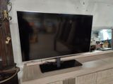 un grand téléviseur à écran plat posé sur un meuble TV en bois
