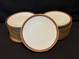 four white plates with gold rims are stacked on a black table