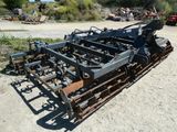 a close up of a tractor plow sitting on a dirt field