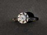 a close up of a diamond ring on a black surface
