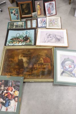beaucoup d'œuvres d'art encadrées posées par terre dans une pièce