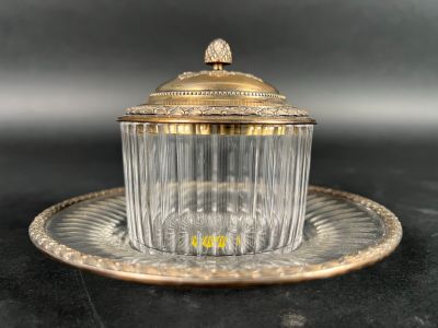 an antique glass cup and saucer on a plate on a black surface