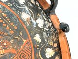 a close up of a decorative tray on a white surface