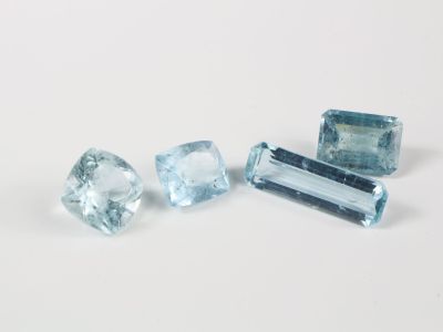 trois pierres précieuses de topaze bleue posées sur une surface blanche