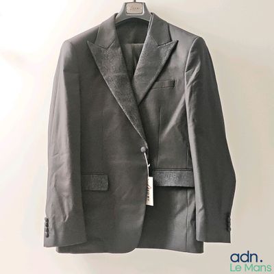 a suit hanging on a hanger on a wall