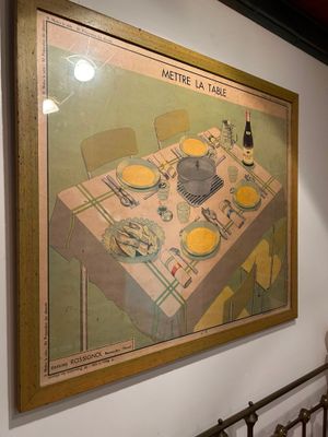 a painting on the wall of a dining room with a table and chairs