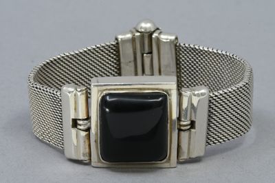 un gros plan d'un bracelet en argent orné d'une pierre noire