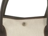 a close up of a brown and white purse with a brown handle