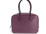 un sac à main en cuir d'autruche violet sur fond blanc