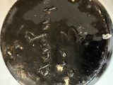 a dirty toilet with a black lid on it