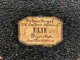 a close up of a label on a black and gold vase