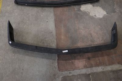 On voit le pare-chocs avant d'une voiture dans un garage
