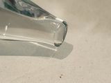 a clear glass object on a table with a white background