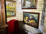 a red chair in front of two paintings on the wall