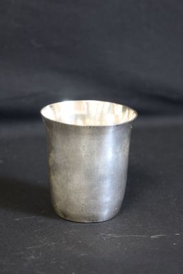 une vieille coupe en argent posée sur une table noire
