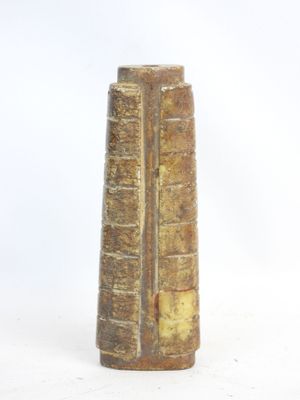a tall vase that has a book on top of it