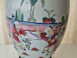a vase that is sitting on a table with a lamp on it