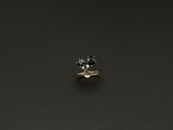 une bague en diamant noir et blanc posée sur une surface noire