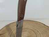 a knife that is sitting on top of a piece of wood