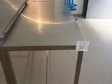 une table en acier inoxydable sur laquelle est posé un ordinateur portable