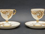 two cups and saucers are sitting on a plate on a table