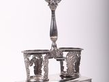un plat ancien en argent orné d'un bougeoir sur pied