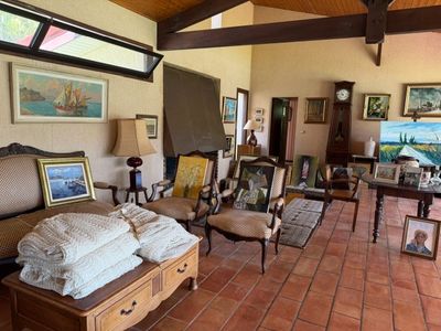 un salon avec beaucoup de meubles et de tableaux accrochés aux murs