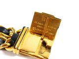 a close up of a gold plated bracelet on a white surface