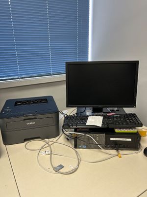 un bureau sur lequel se trouvent un ordinateur, une imprimante et une souris