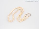 un gros plan d'un collier de perles muni d'un fermoir, sur fond blanc