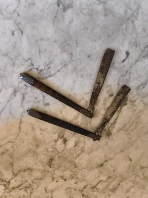 trois clous posés par terre les uns à côté des autres