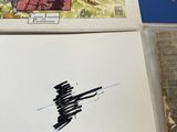 three books on a table with a drawing of a plane on it