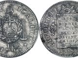 une pièce d'argent sur laquelle figurent des armoiries