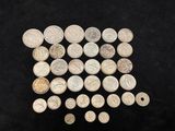 a pile of silver coins sitting on top of a black surface