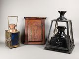 Trois types différents de lanternes anciennes sont exposés sur un support blanc