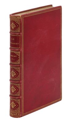 un vieux livre rouge avec des bordures dorées sur la couverture