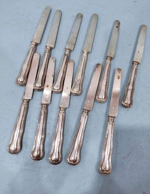 six silverplated knives and six knives on a blue surface