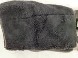 a close up of a black blanket on a white surface