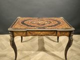 a small table with a marble top on a wooden floor