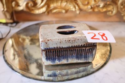 une petite boîte en céramique sur laquelle est accrochée une étiquette de prix