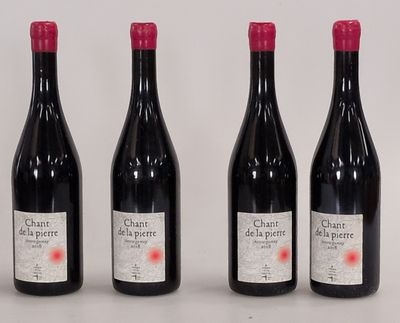 four bottles of wine are lined up on a white surface