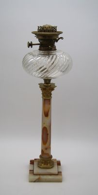 une lampe en verre posée sur un socle en marbre
