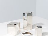 quatre pièces métalliques argentées sur une surface blanche